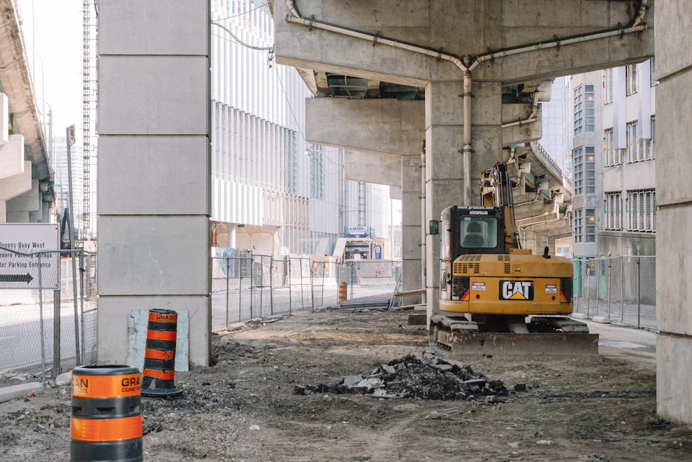 A digger parked under a bridge on a building site